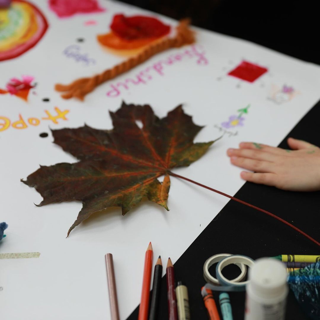 A large autumn leaf and painted rainbow on the collage